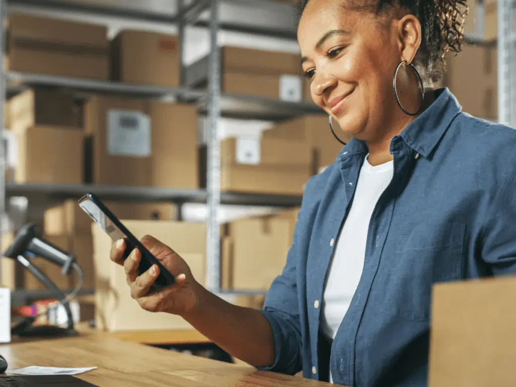 Inventory manager using a tablet to check stock on warehouse racks, showing traceability and FEFO controls