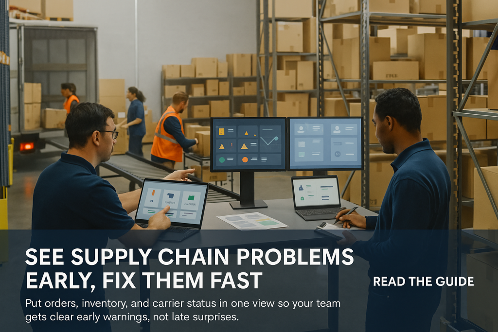 Two planners review control tower dashboards in a busy warehouse while workers load cartons onto a trailer.