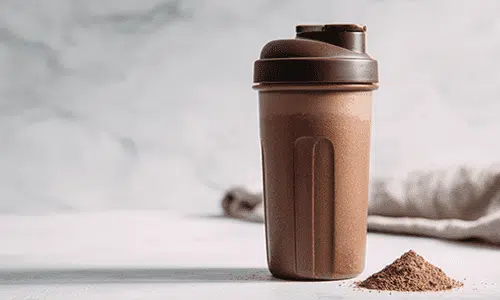 Protein shaker bottle with powder on a tabletop illustrating health and wellness products